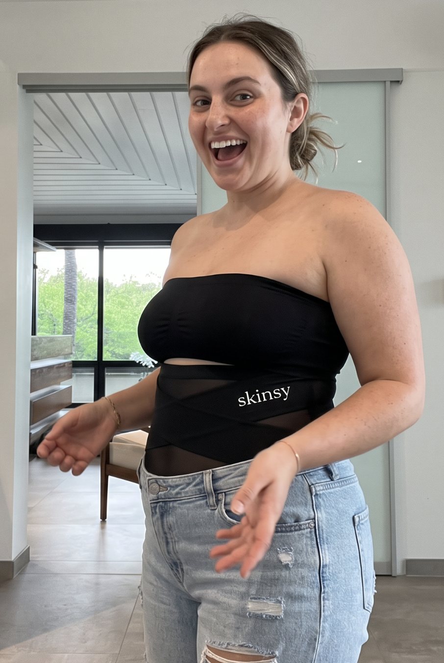 Woman laughing while trying on the black Skinsy brief