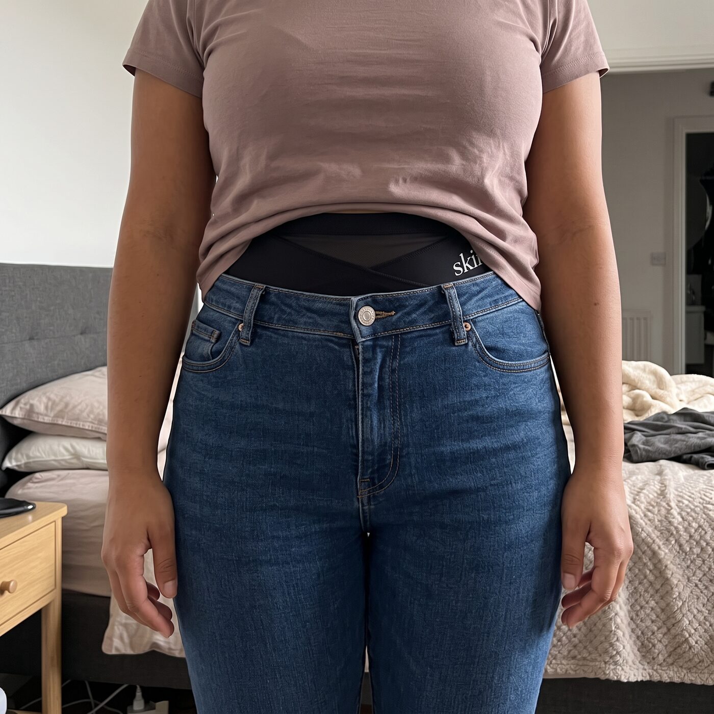 Jeans buttoned over the brief